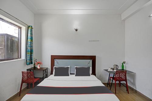a bedroom with a large bed and two chairs at Hotel Naveen Stay in Manesar