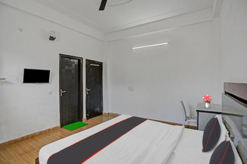 a bedroom with a bed and a flat screen tv at Hotel Naveen Stay in Manesar