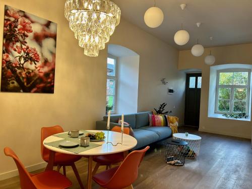a living room with a blue couch and a table at Kalnamuiža Apartments in Smiltene