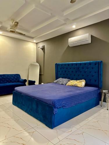 Cama grande azul en habitación con sofá en Comfy First Floor Portion In BTK, en Karachi
