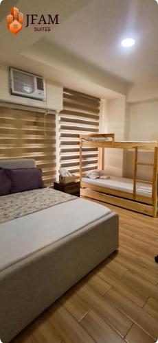 a bedroom with two beds and a tv on the wall at JFam Suites, C1-5L 1BR , Up To 7 Pax in Biñan