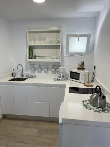 a white kitchen with a tea kettle on a counter at Oasis Playa Maspalomas in Maspalomas