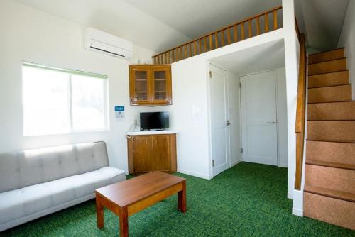 un salon avec un canapé et une table dans l'établissement Nagai Peony Forest Campsite - Vacation STAY 27777v, à Yamagiwa