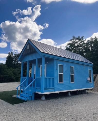 a blue tiny house on a gravel lot at Nagai Peony Forest Campsite - Vacation STAY 27777v in Yamagiwa