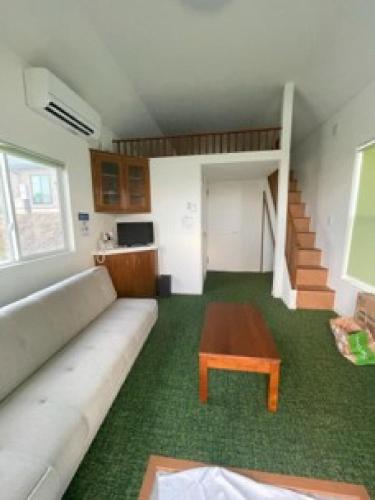 a living room with a couch and a coffee table at Nagai Peony Forest Campsite - Vacation STAY 27777v in Yamagiwa