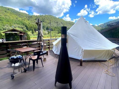 a white tent on a deck with a table and chairs at Unno Glamping - Vacation STAY 27780v in Nantan city