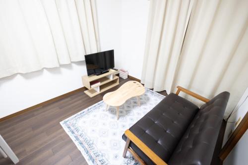a living room with a black couch and a table at Tokorozawa - House - Vacation STAY 16364 in Tokorozawa