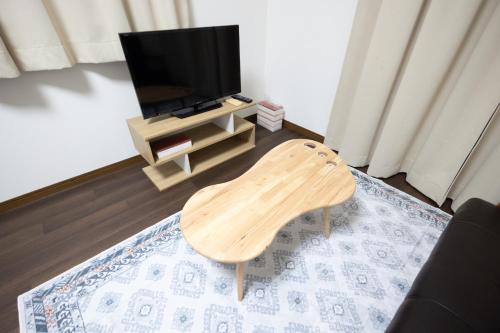 a living room with a wooden chair in front of a tv at Tokorozawa - House - Vacation STAY 16364 in Tokorozawa