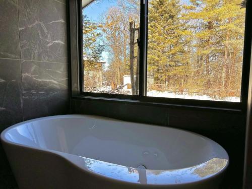 a bath tub in a bathroom with a window at HARUNA VILLA - Vacation STAY 27961v in Kita-karuizawa