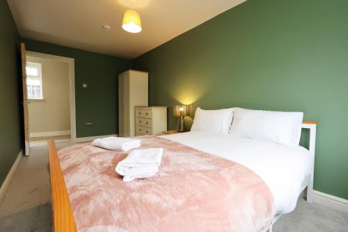 Un dormitorio con una cama grande con dos toallas encima. en Perfect Bridgend Stay: Comfort & Space!, en Bridgend