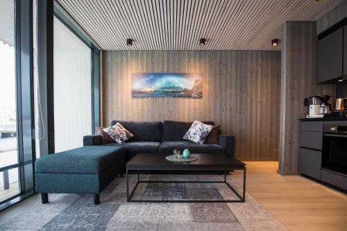a living room with a couch and a coffee table at Opplev nordlyset og bo ved sjøkanten! in Henningsvær