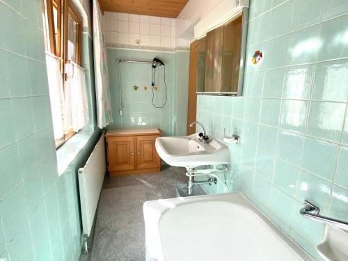 a blue bathroom with a sink and a tub and a sink at Haus I'mperfect in Stumm