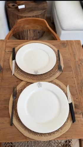 a table with two white plates and utensils on it at Bed and Breakfast Bij ons in het bos in Bergen op Zoom