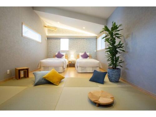 a room with two beds and a potted plant at MORIHAKU - Vacation STAY 34533v in Kutsukake
