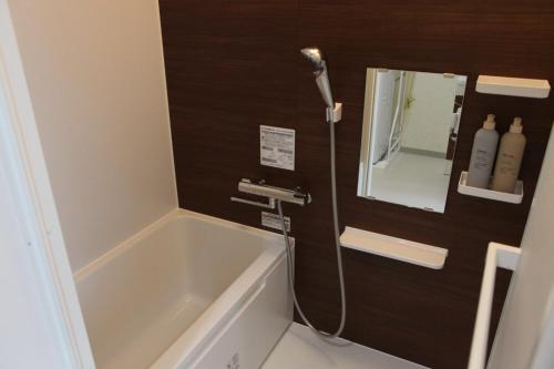 a bathroom with a tub and a sink and a mirror at MARINO1 - Vacation STAY 40074v in Fukuyama