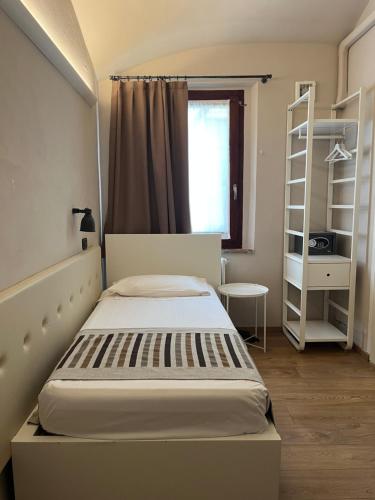 a small bedroom with a bed and a window at A Casa Dei Gonzaga, MantegnaHotels in Mantova