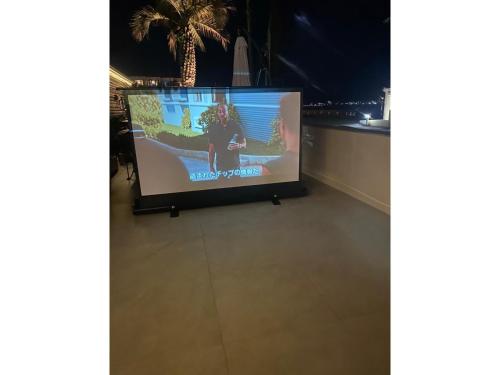a tv screen with a person standing on it at OCEAN FRONT TATEYAMA - Vacation STAY 66625v in Tateyama