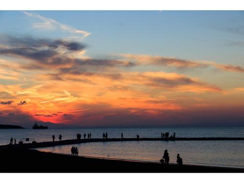 a group of people on the beach at sunset at OCEAN FRONT TATEYAMA - Vacation STAY 66625v in Tateyama