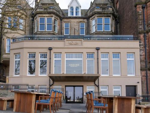 a building with chairs in front of it at Seaton House - Small Luxury Hotels of the World in St. Andrews