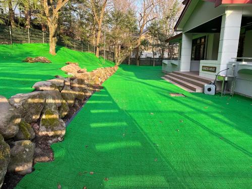 a yard with green grass and a retaining wall at GONZOU-HOUSE - Vacation STAY 42967v in Zao