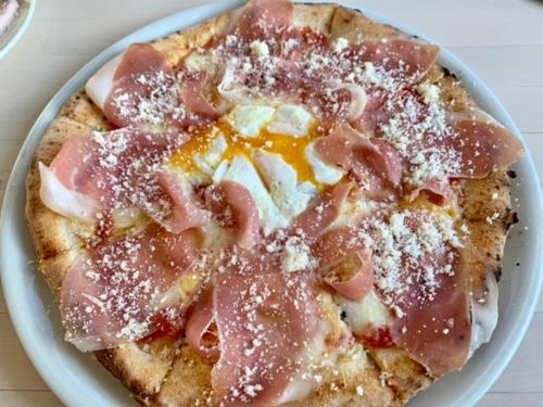 a pizza with bacon on a plate on a table at OCEAN FRONT TATEYAMA - Vacation STAY 61331v in Tateyama