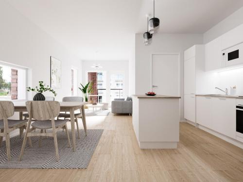 a kitchen and dining room with white cabinets and a table at Snownest Premium City Centre Apartments 1 in Rovaniemi