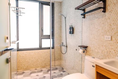 a bathroom with a shower and a toilet and a sink at 春喃日光 Whispring Inn in Hengchun