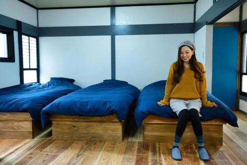 a girl sitting on a bed in a room with two beds at Ohruri, a camp-style inn where you can enjoy a bon - Vacation STAY 48658v in Iwai