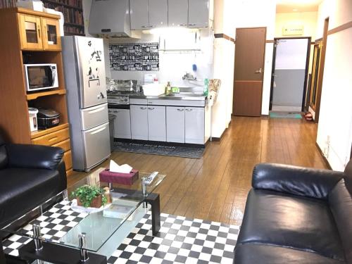 a living room with a couch and a kitchen at KY Apartment - Vacation STAY 40189v in Naha