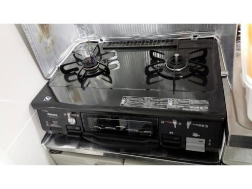 a stove top oven sitting inside of a refrigerator at KY Apartment - Vacation STAY 40189v in Naha
