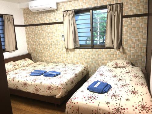 two beds in a room with blue towels on them at KY Apartment - Vacation STAY 40189v in Naha