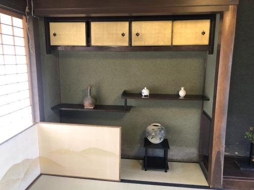 a room with shelves and vases on a wall at Himeji Castle's inner sanctum 400-year-old - Vacation STAY 16474 in Fukusaki