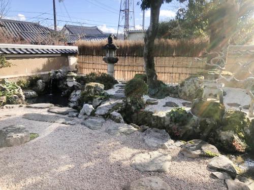 a garden with rocks and a tree and a fence at Himeji Castle's inner sanctum 400-year-old - Vacation STAY 16474 in Fukusaki