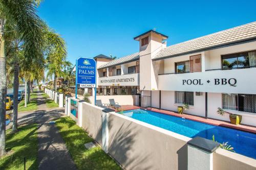 a hotel with a swimming pool in front of a building at Cairns City Palms in Cairns