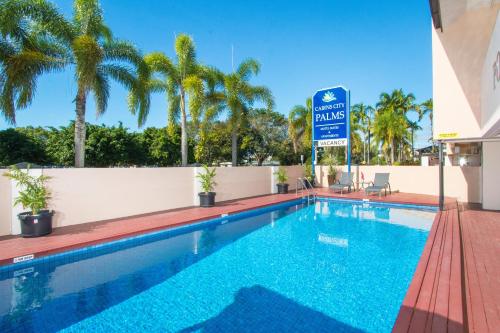 a swimming pool at a hotel with a sign that reads embassy palms at Cairns City Palms in Cairns