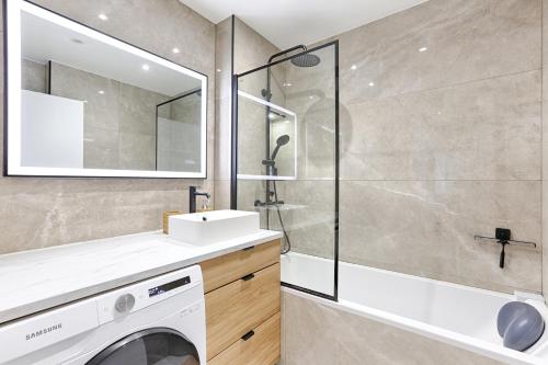 a bathroom with a sink and a washing machine at Superbe appartement pour 6P aux portes de Paris in Saint-Maurice