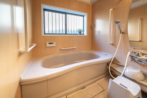 a bath tub in a bathroom with a window at Midori-an - Vacation STAY 56541v in Kikugawa