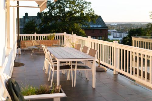a wooden table and chairs on a balcony at Sekelskifte villan in Huskvarna