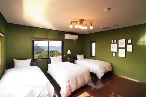 富津市にあるMayoruca House - Vacation STAY 58312vの緑の壁の部屋にベッドが2つある