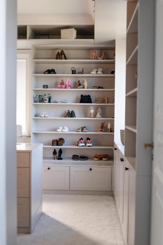 a walk in closet with shelves filled with shoes at Sekelskifte villan in Huskvarna
