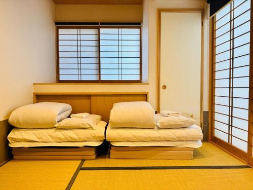 Dos camas en una habitación con ventana. en Zennichi - Vacation STAY 15750v, en Kioto