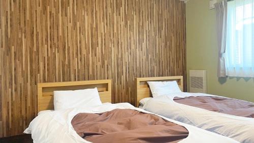 美瑛町にあるCondominium Biei Nakamachi - Vacation STAY 48311vの寝室に並んで置かれた2つのベッド