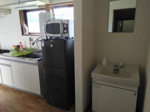 una cucina con un forno a microonde sopra un frigorifero di Miyori Hometown Experience Village Campsite (Nakam - Vacation STAY 34963v a Nikko