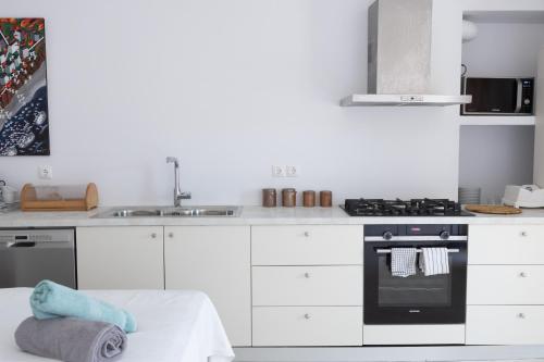 a white kitchen with a sink and a stove at Melita home in Mesochórion