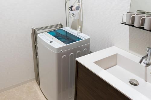 Un baño blanco con lavabo y espejo. en Zennichi - Vacation STAY 60323v, en Kioto