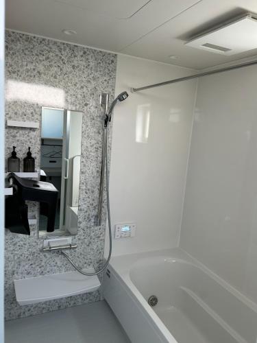 a bathroom with a tub and a sink and a mirror at nyans - Vacation STAY 60127v in Matsue
