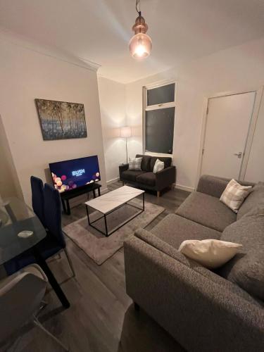 a living room with a couch and a table at Contractor home close to centre and motorway links in Liverpool