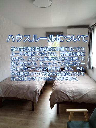 a room with two beds and a window with a curtain at Guesthouse Senba - Vacation STAY 16626 in Mito
