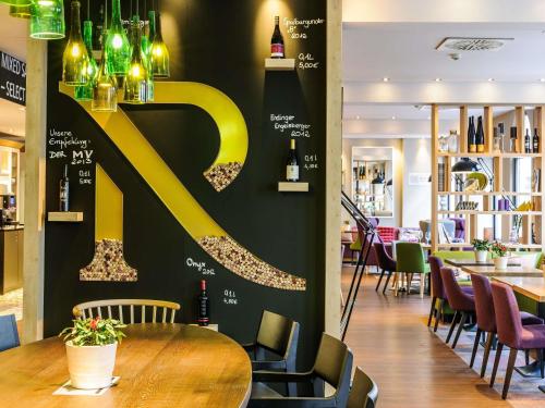 a restaurant with a large yellow letter k on a wall at Mercure München City Center in Munich