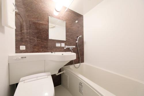 a bathroom with a white toilet and a sink at Kaike Fuga in Yonago